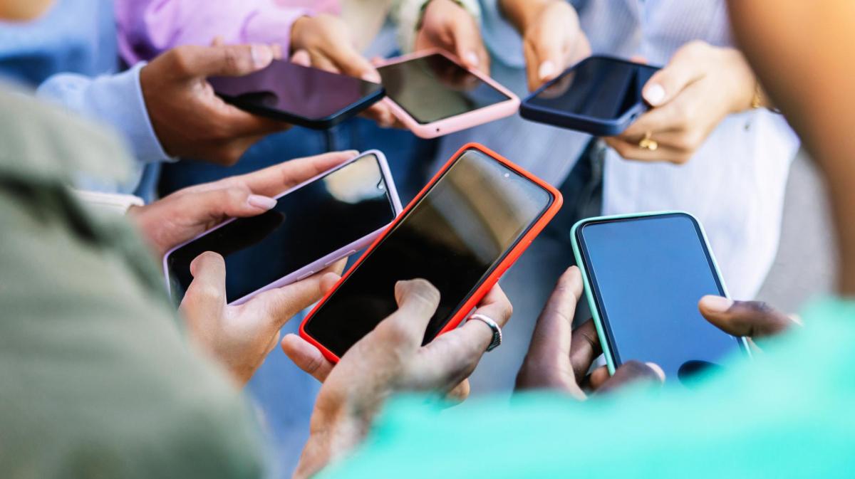 Mehrere Personen mit vielen verschiedenen Smartphones.