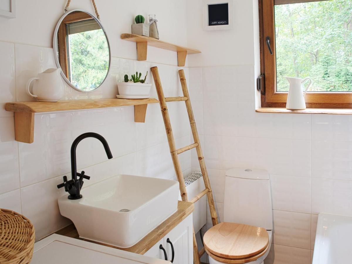 Ein kleines Badezimmer mit vielen Holzelementen und einem Fenster.