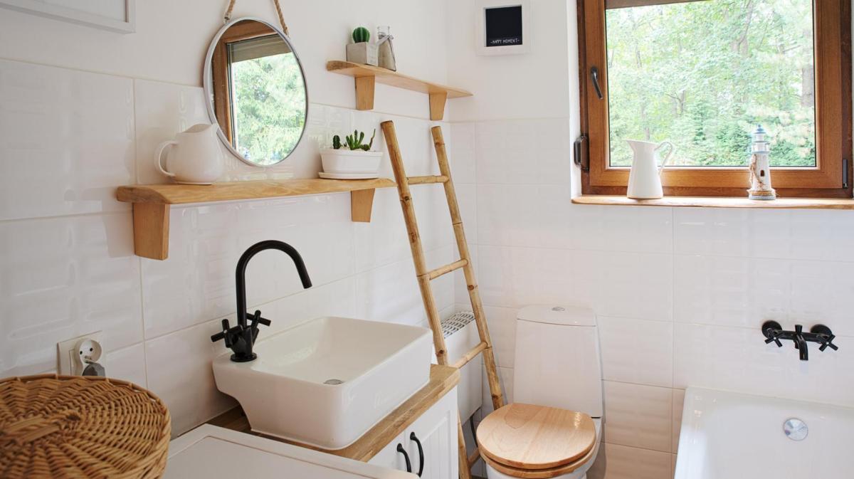 Ein kleines Badezimmer mit vielen Holzelementen und einem Fenster.