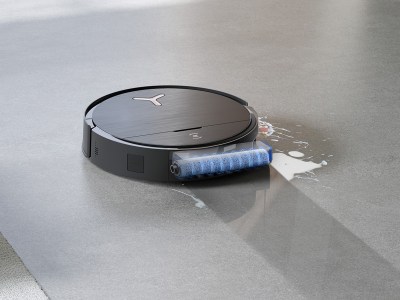 Der OZMO ROLLER entfernt verschiedene Verschmutzungen durch konstanten Druck, Rotation und permanente Wasserzufuhr besonders gründlich und sorgt so für streifenfreie Sauberkeit. Schwarzer Saug- und Wischroboter auf grauem Boden reinigt ausgelaufene Milch mit einer rotierenden blauen Bürstenwalze.