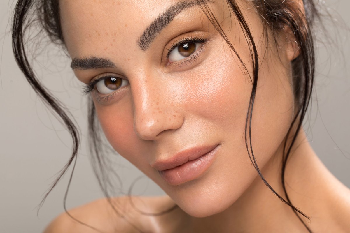 Frau mit ebenmäßiger Haut und einem schönen Glow im Gesicht.