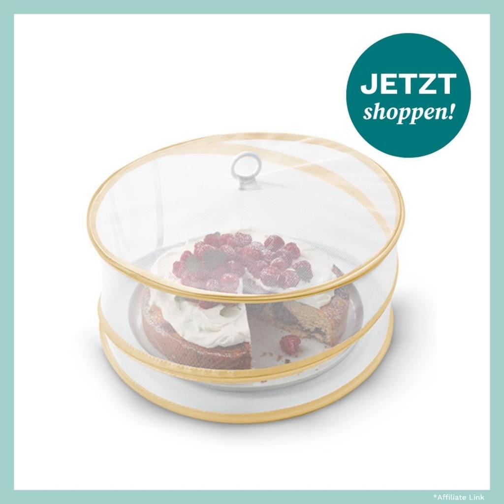 Produktbild einer Abdeckhaube von Tchibo. Darunter befindet sich eine Torte.