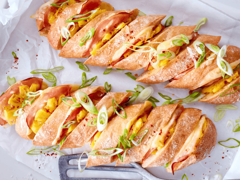Hasselback-Baguettes mit Käse, Ananas und Schinken.