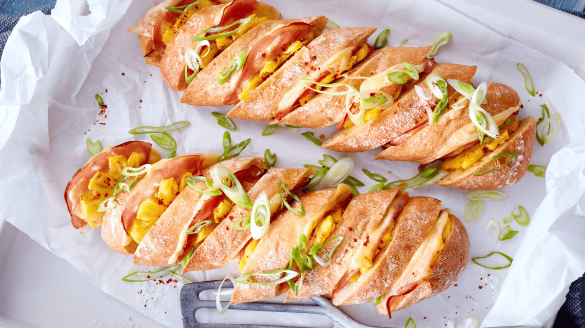 Hasselback-Baguettes mit Käse, Ananas und Schinken.