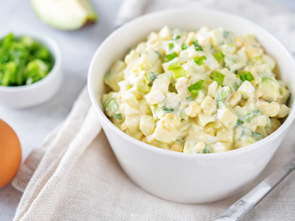Eine Sch&uuml;ssel mit Eiersalat steht auf einem Tisch mit Tischdecke.