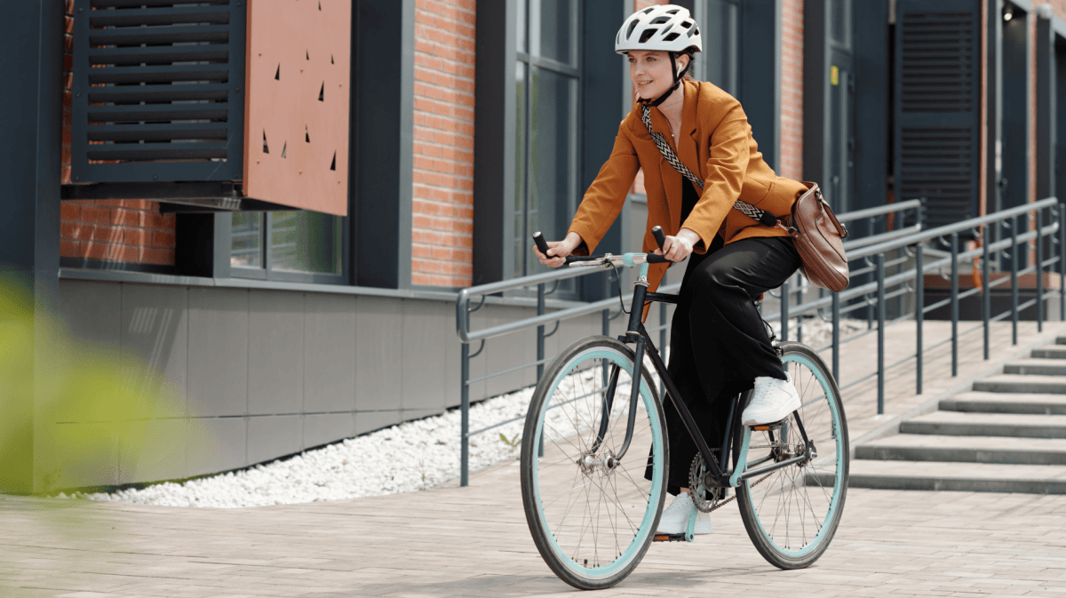 Junge Frau fährt mit Fahhrad zur Arbeit.