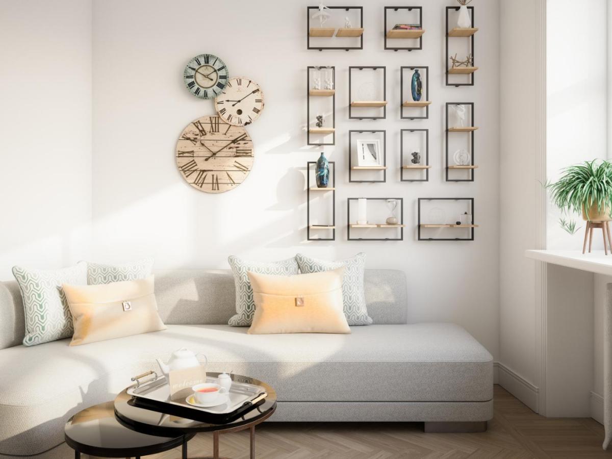 Ein helles Wohnzimmer vor einer Bilderwand.