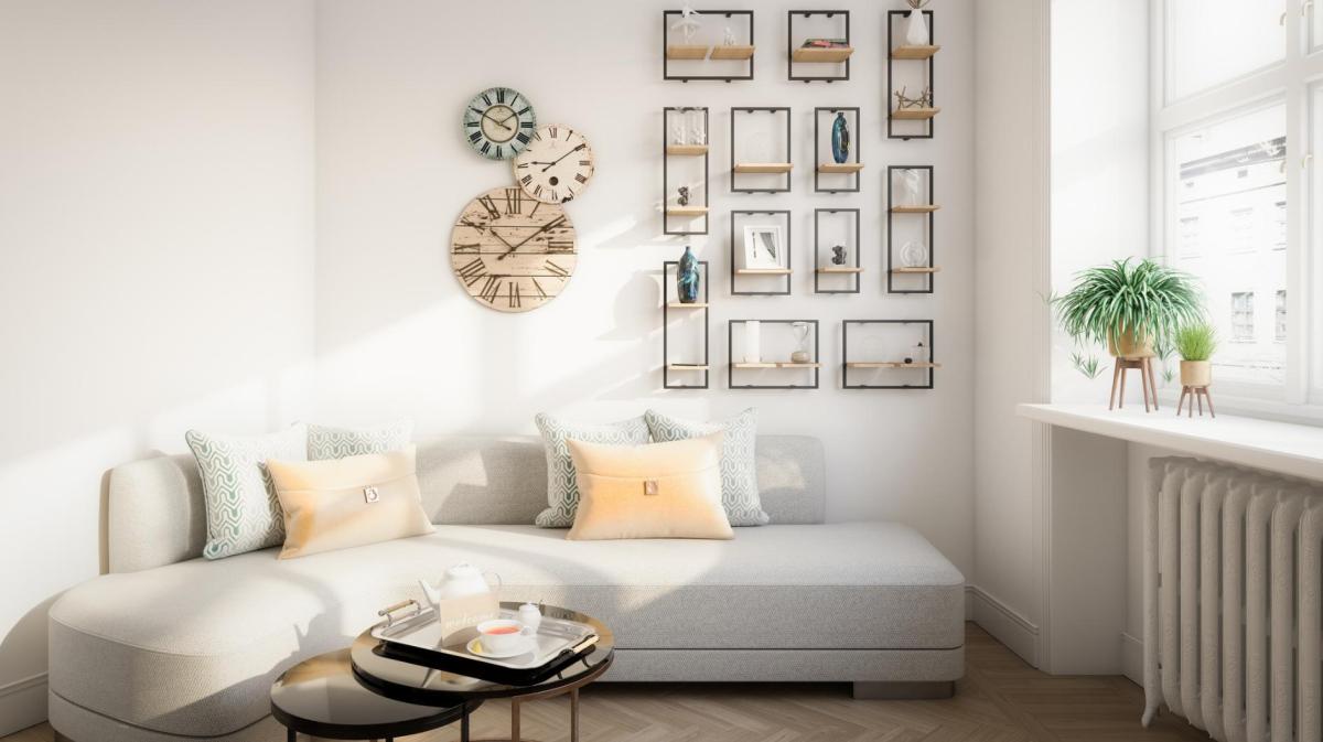 Ein helles Wohnzimmer vor einer Bilderwand.