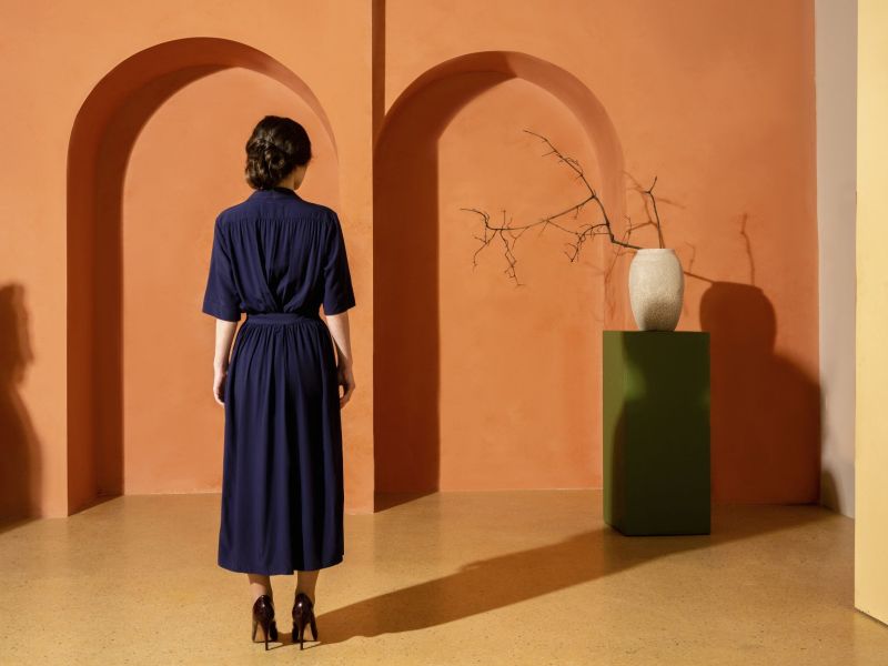 Frau von hinten vor orangener Wand als Symbolbild für Negging