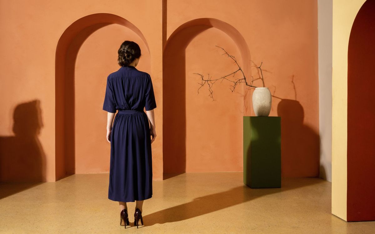 Frau von hinten vor orangener Wand als Symbolbild für Negging