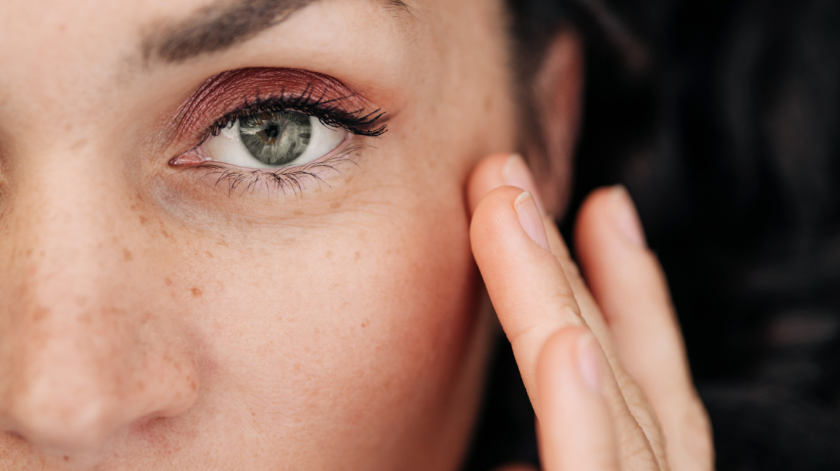 Frau mit intensivem Blick trägt Rouge auf