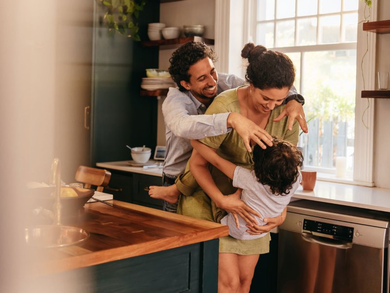Eltern albern mit ihrem Sohn in der Küche rum.
