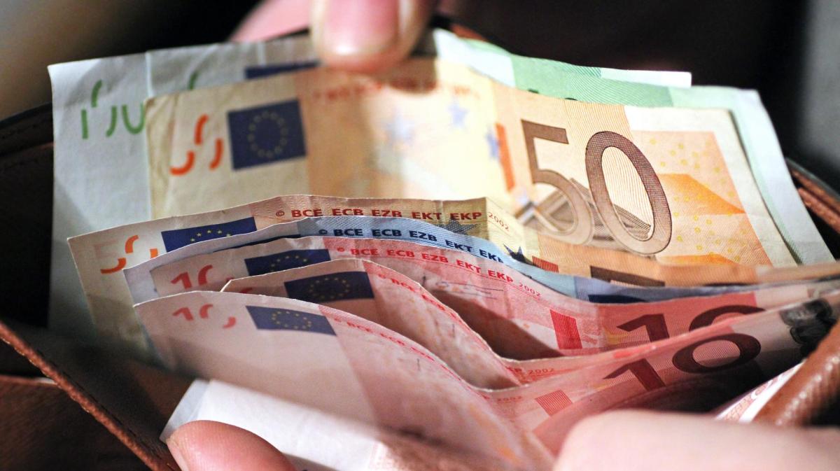 Frau sortiert Geld im Portemonnaie.