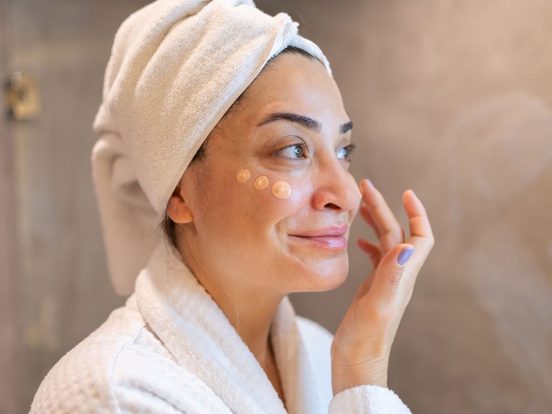 Frau, die eine getönte Tagescreme im Gesicht aufträgt.