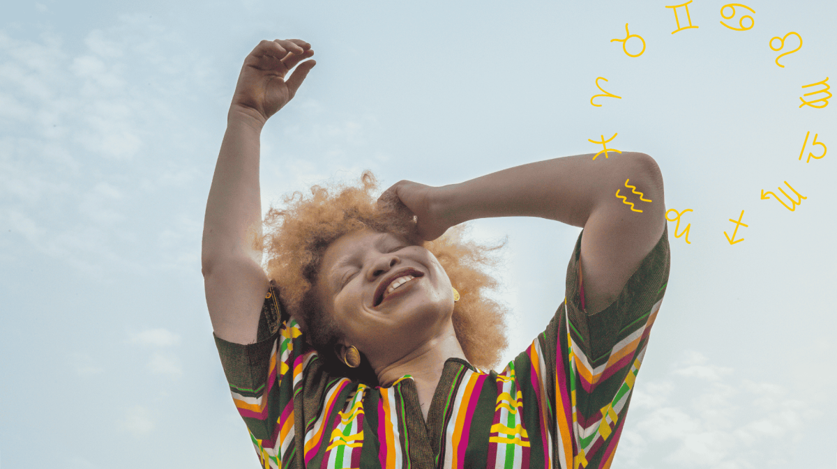 Frau streckt lächelnd ihre Arme in den Himmel