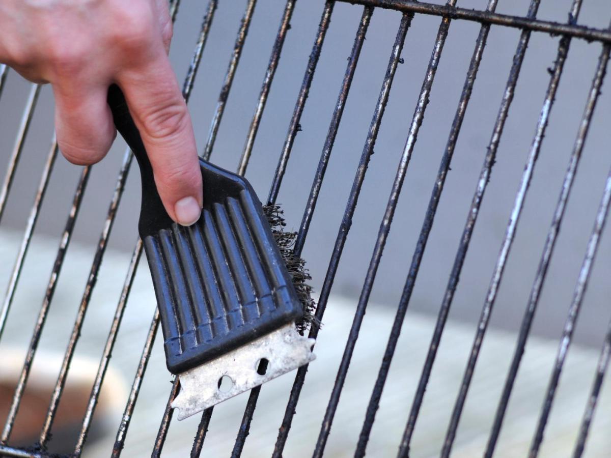Grillrost wird mit einer B&uuml;rste gereinigt.