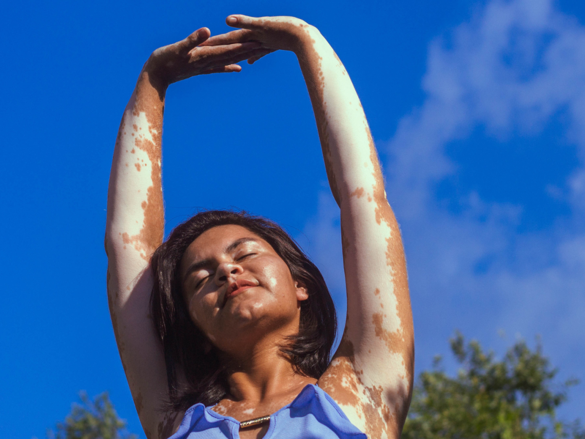 Frau, die sich unter blauem Himmel streckt.