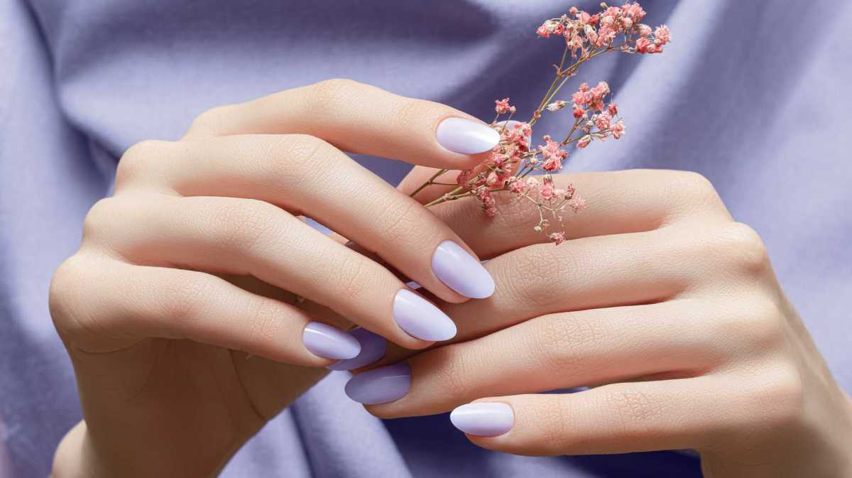 Lila lackierte Fingernägel halten eine Blume fest