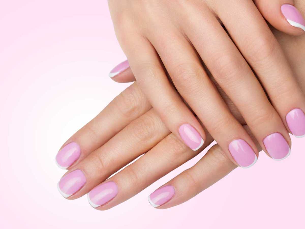 N&auml;gel mit French Design vor einem rosa Hintergrund