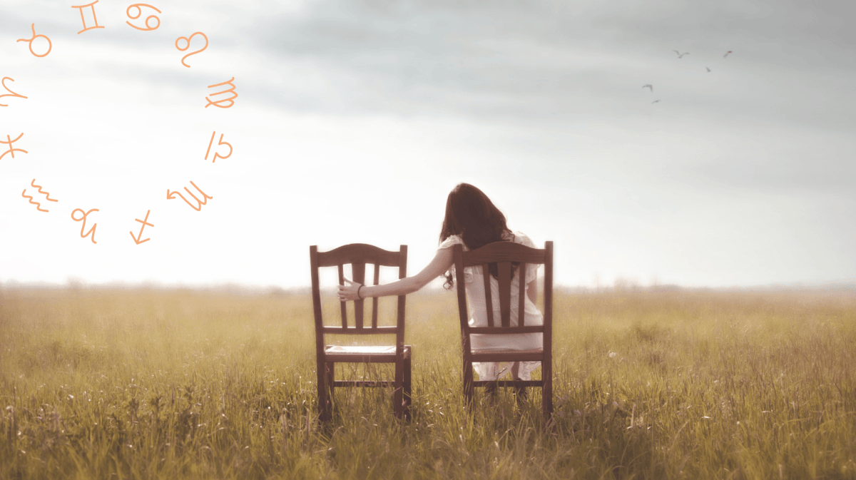 Frau sitzt auf dem Feld auf einem Stuhl und hält Hand auf leeren Stuhl neben ihr