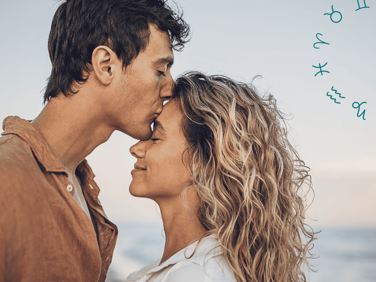 Mann k&uuml;sst Frau am Strand auf die Stirn