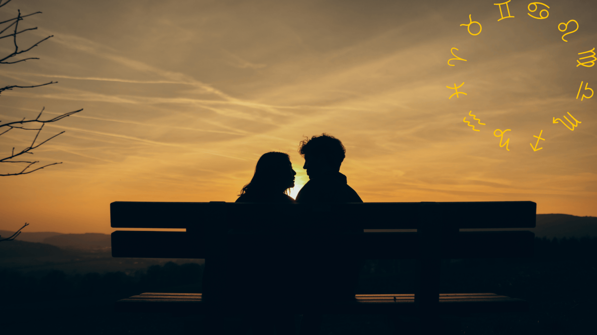 Frau und Mann sitzen bei Sonnenuntergang auf einer Bank und schauen sich an.