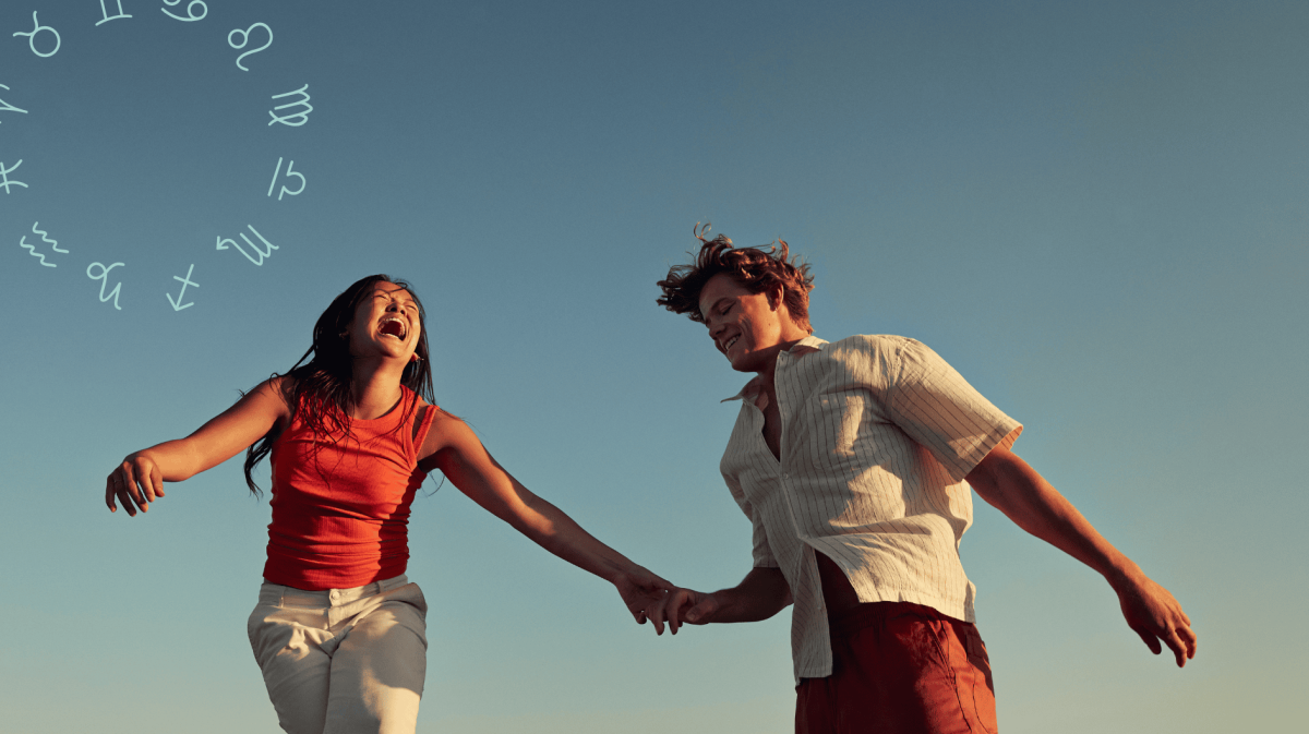 Frau und Mann halten sich an der Hand und lachen zusammen vor blauem Himmel