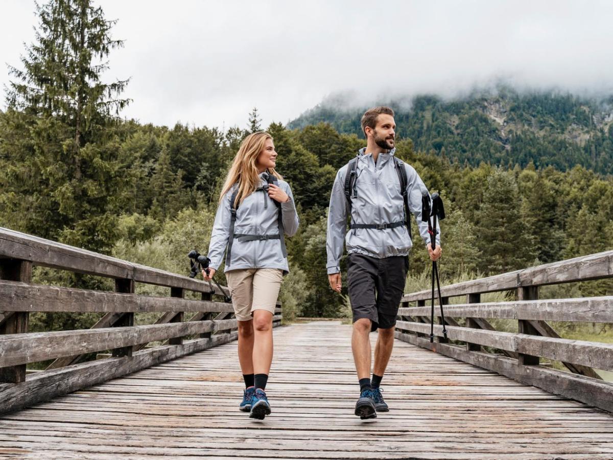 Mann und Frau gehen gerade auf einer Brücke beim Wandern.