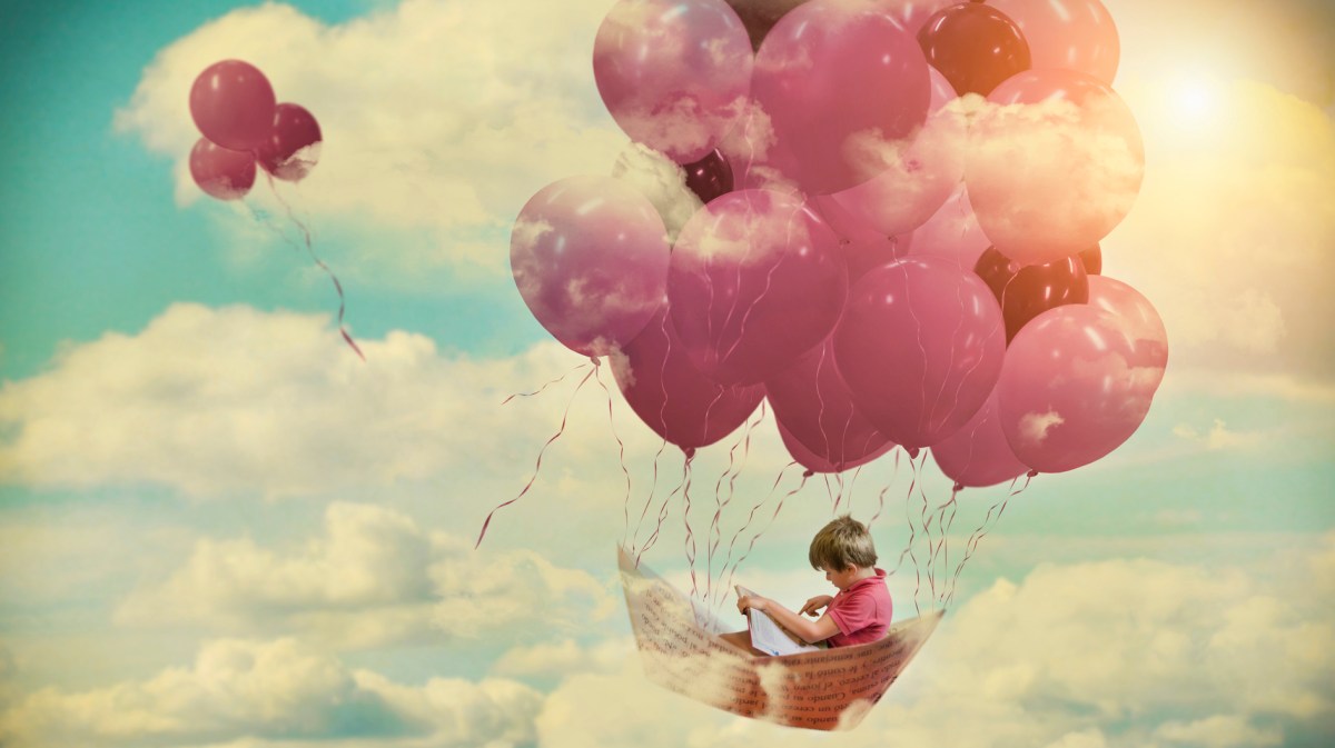 Kleiner Junge sitzt in einem Boot und schwebt auf Luftballons durch die Wolken