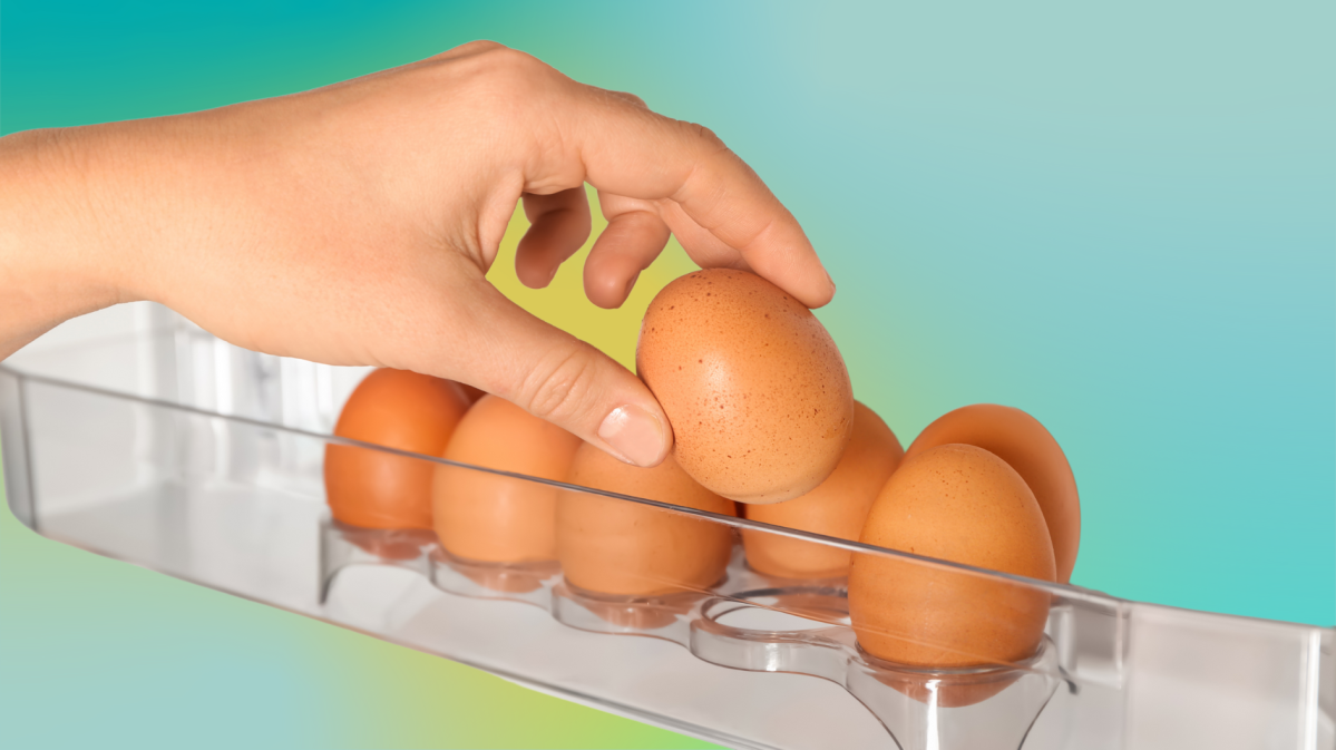 Hand greift nach Eiern im Kühlschrank