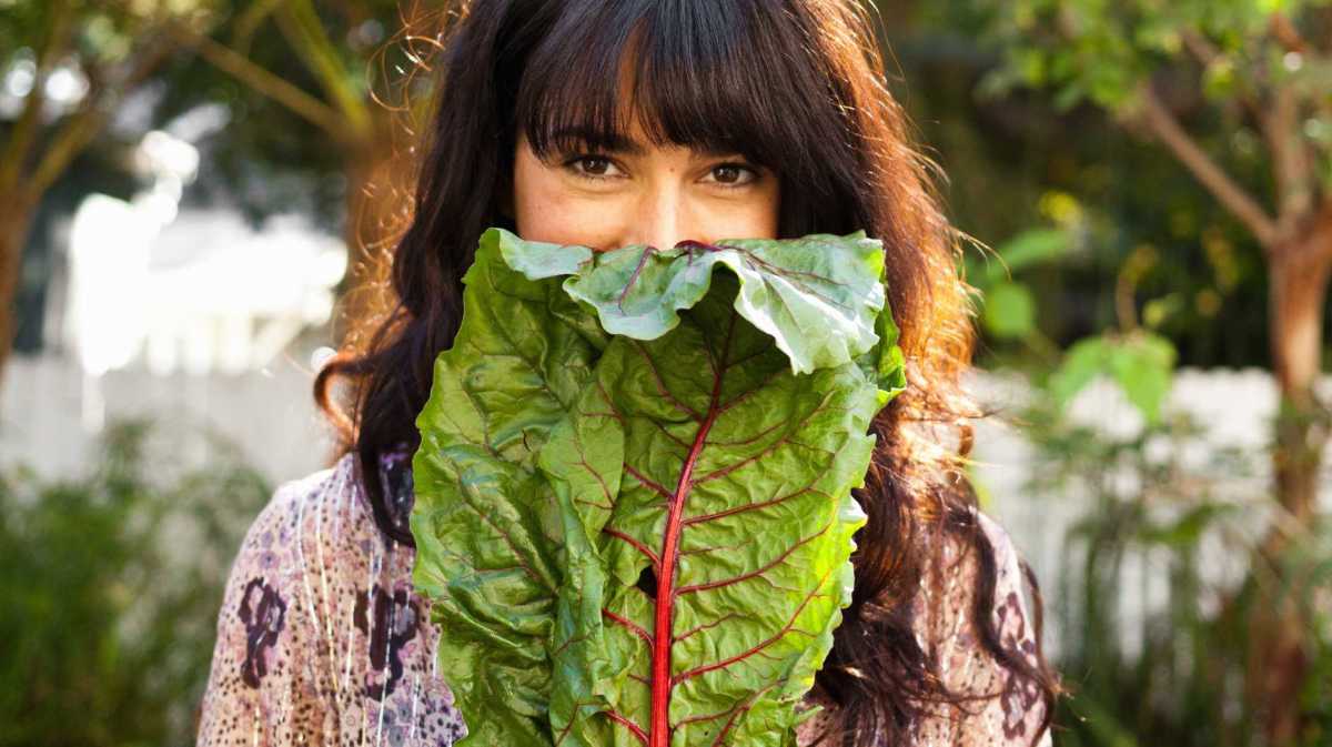 Junge Frau hält Magold-Blatt vor ihrem Gesicht