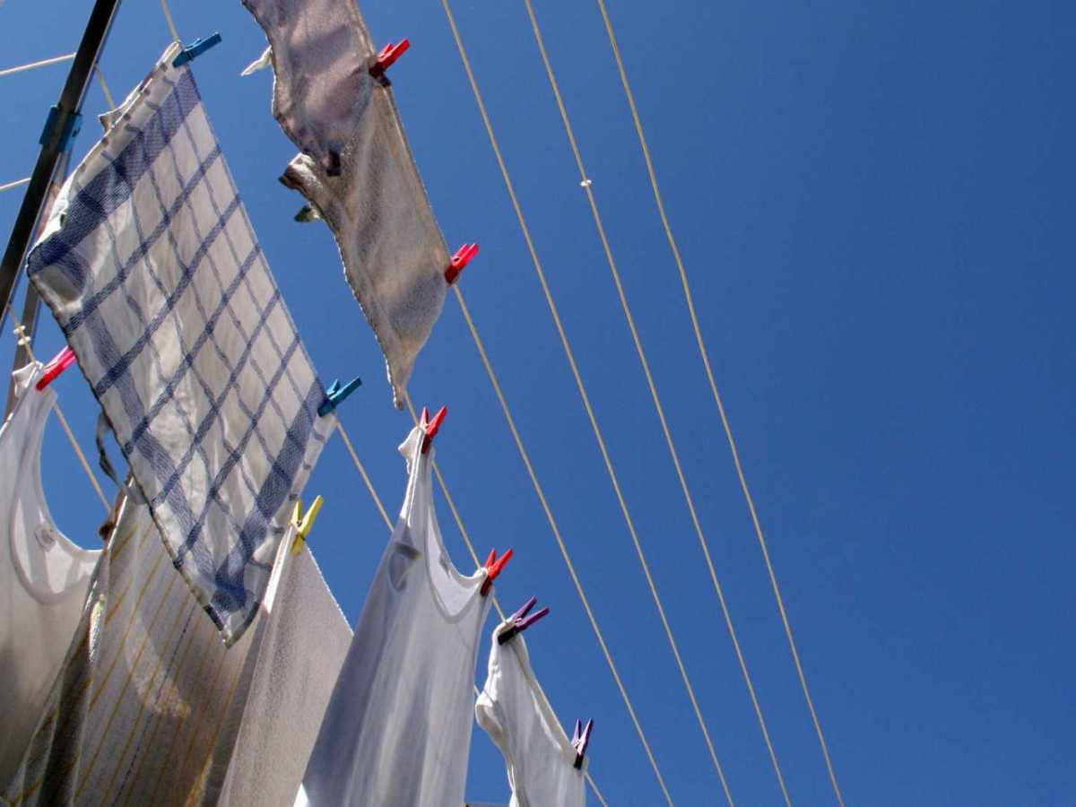 Wei&szlig;e Kleidung h&auml;ngt drau&szlig;en in der Sonne auf einer W&auml;scheleine