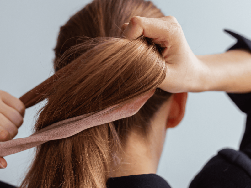 Natürliche blonde Frau macht einen Pferdeschwanz, hält ihr Haar, Stop Motion, Rückansicht,