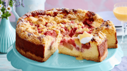 Rhabarber-Käsekuchen auf einer grünen Tortenplatte.