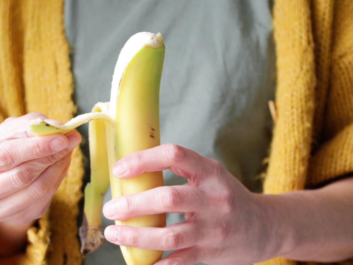 Frau sch&auml;lt eine Bananen.
