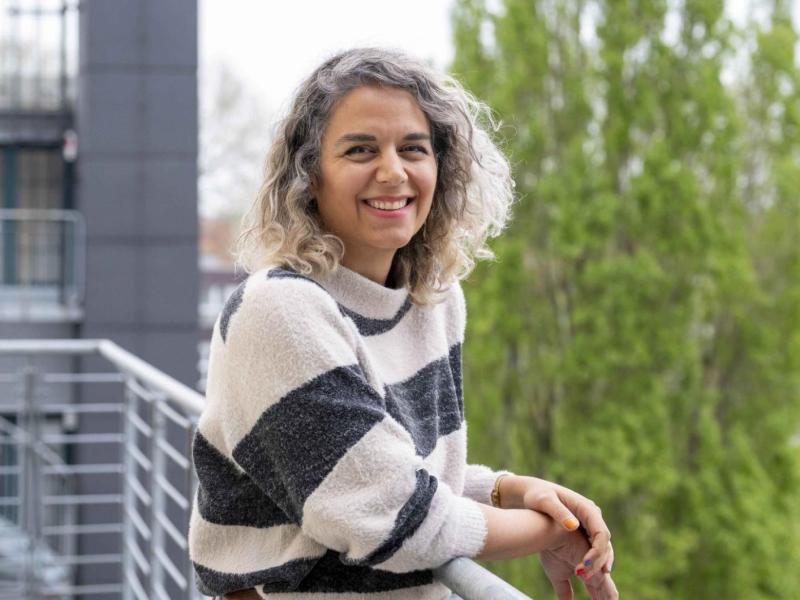 Donya Golafshan lehnt lässig an einem Geländer.