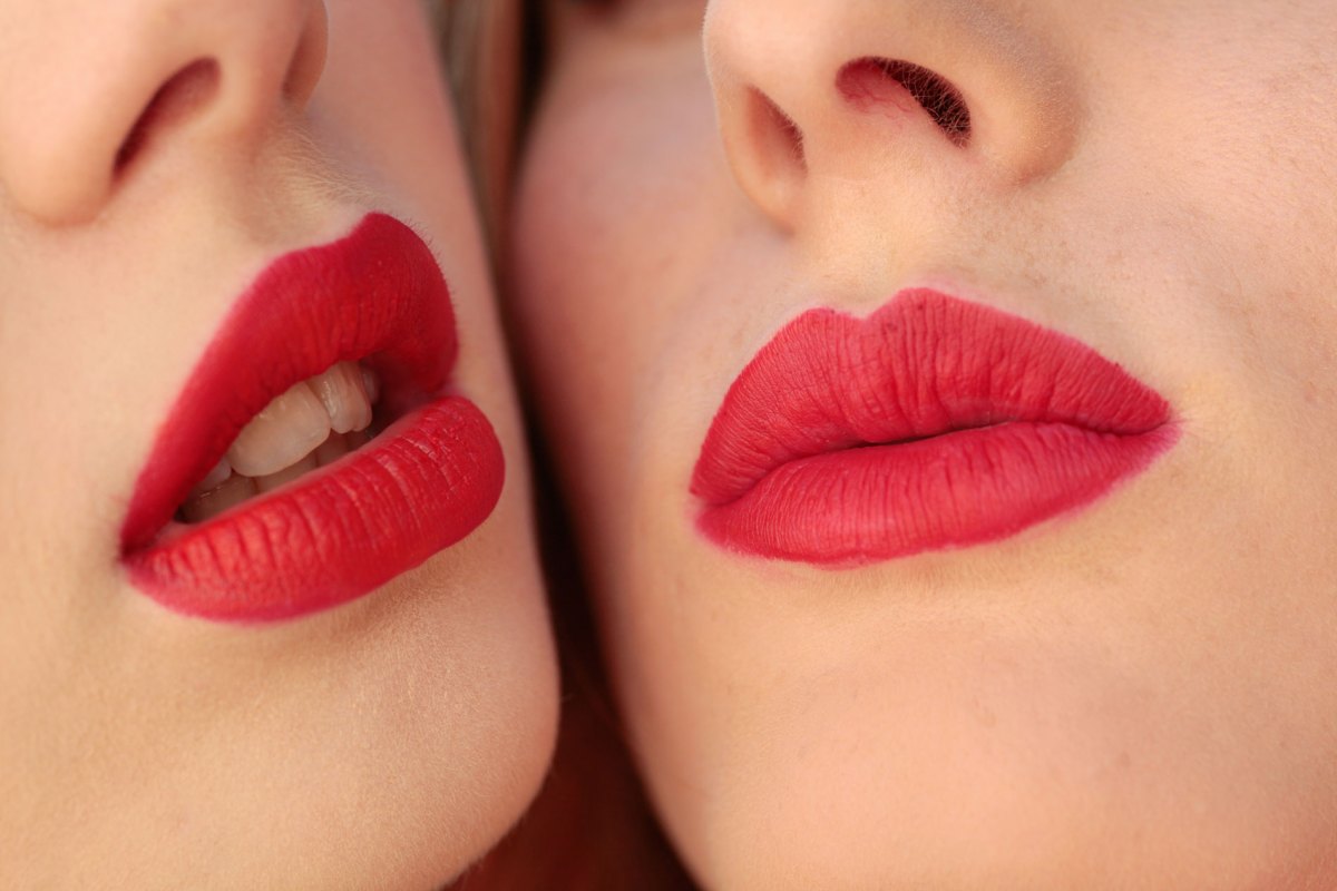 Zwei Frauen mit rot geschminkten Mündern.