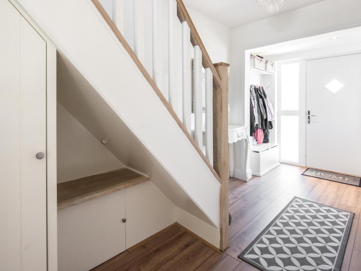 Kleiner Flur mit einer gro&szlig;en Treppe nach oben. auf dem Boden liegen Teppiche.