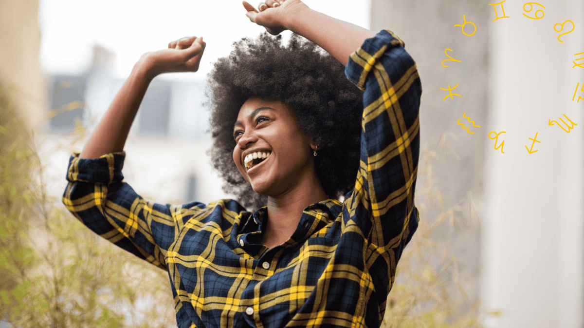 Frau mit kariertem Hemd tanzt und lächelt dabei