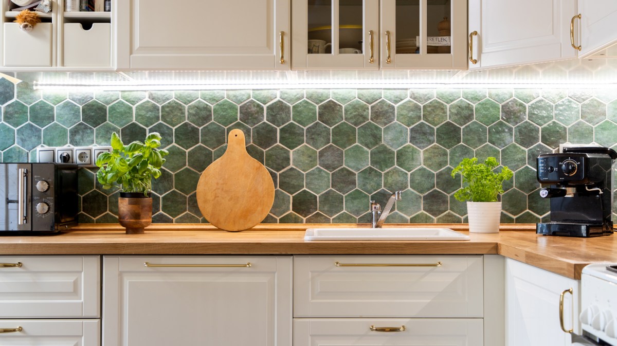 Gepflegte weiße Küche mit grünen Fließen