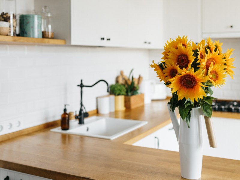 Aufgeräumte Küche mit Sonnenblumen auf dem Tresen