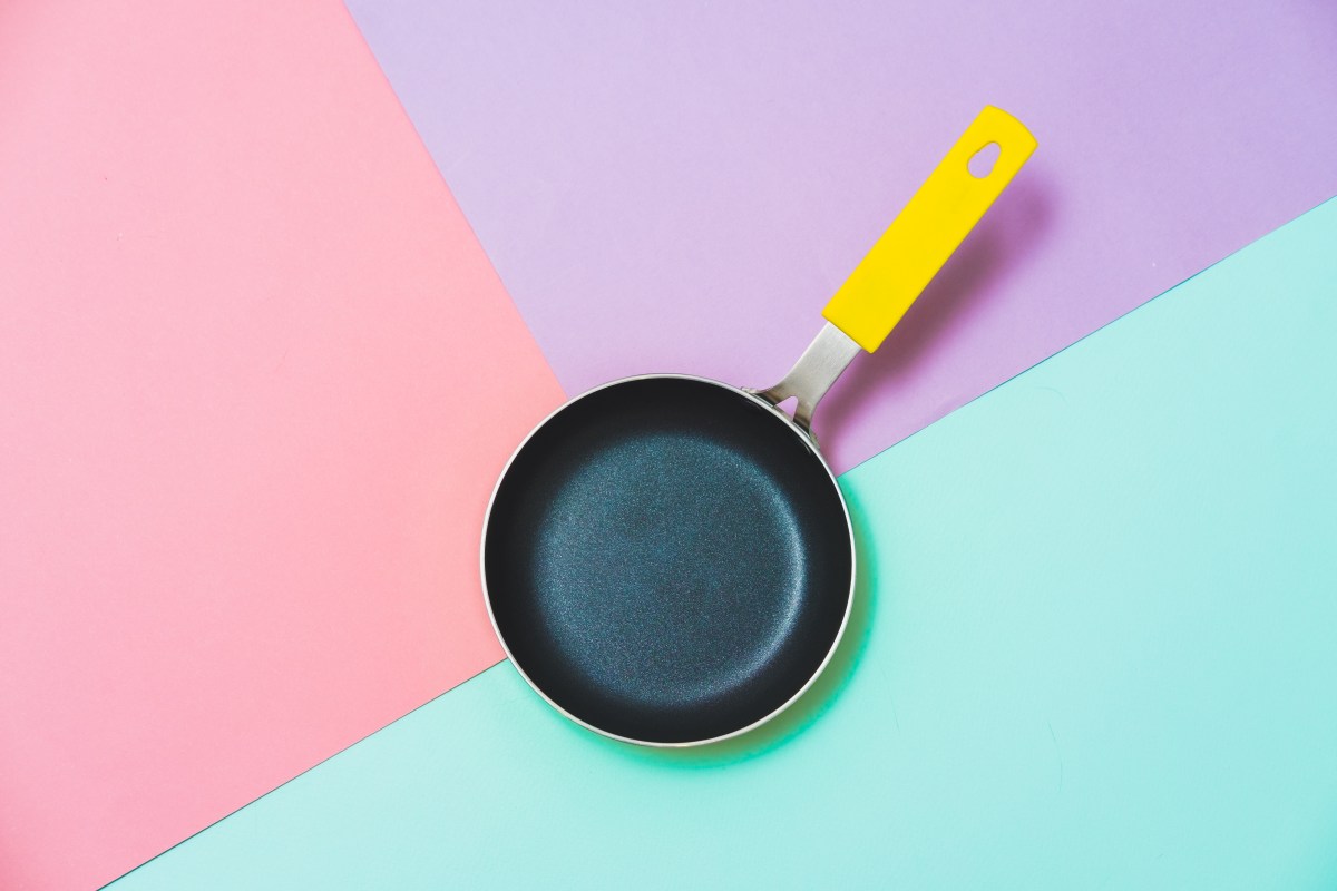 Pfanne mit Loch im Griff auf dreifarbigem Hintergrund