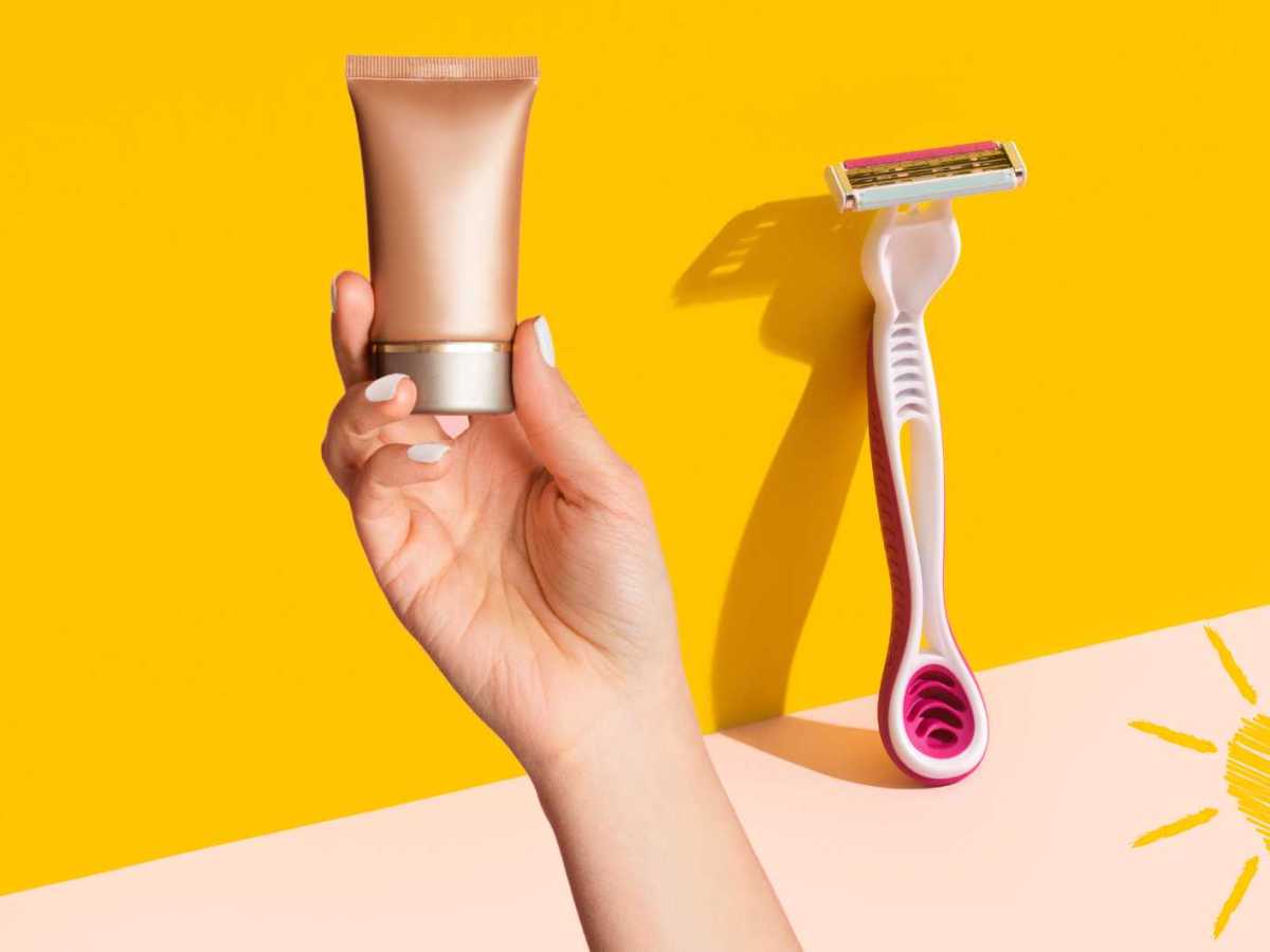 Frau hält Selbstbräuner in der Hand, daneben steht ein Rasierer.