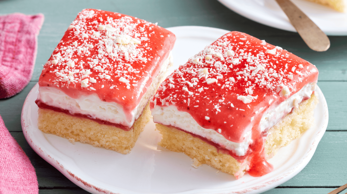 Blechkuchen mit Sahne und Erdbeersoße.