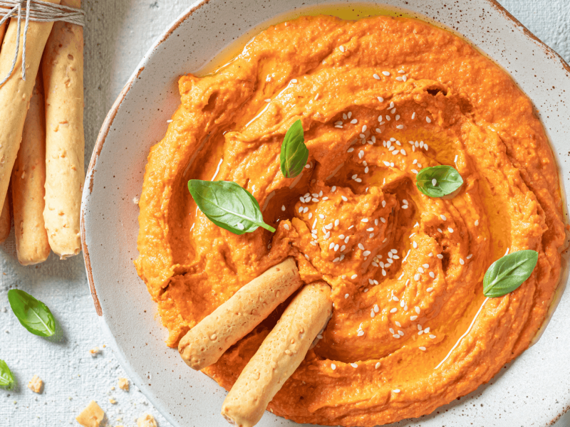 Cremiger Tomate-Mozzarella-Dip in einer weißen Schale.