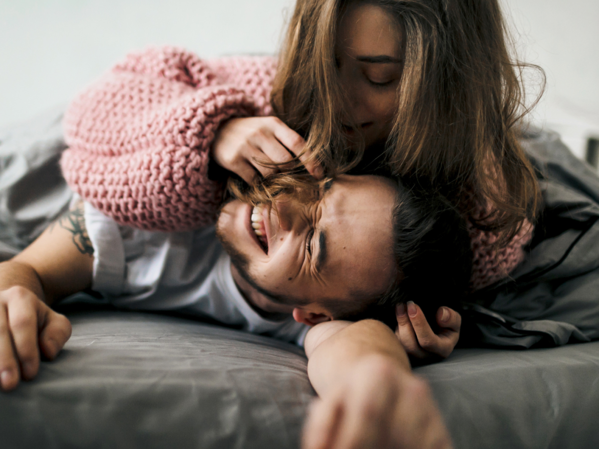 Ein Mann und eine Frau liegen verliebt auf einem Bett