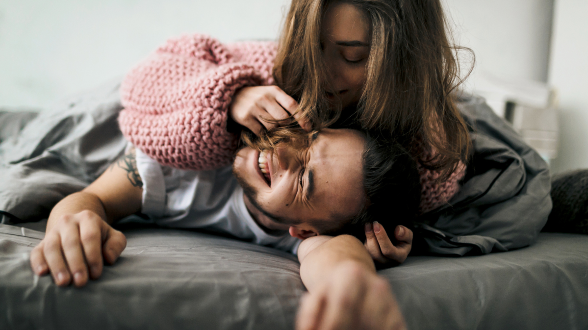 Ein Mann und eine Frau liegen verliebt auf einem Bett