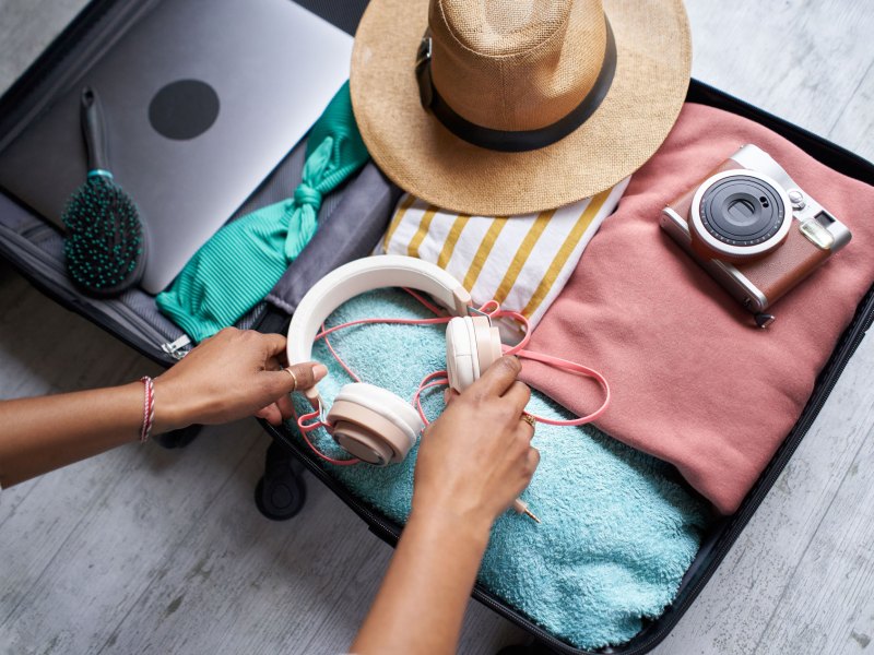 Frau, die ihren Koffer für den Sommer-Urlaub packt.