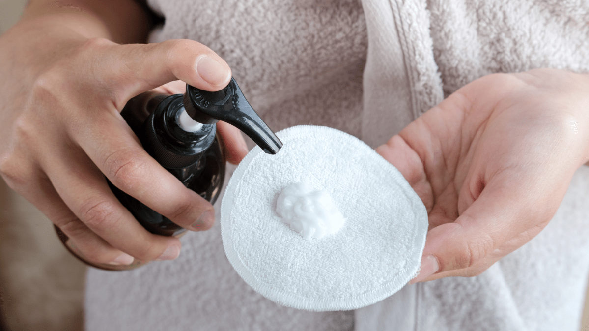 Reiniger auf einem Wattepad.