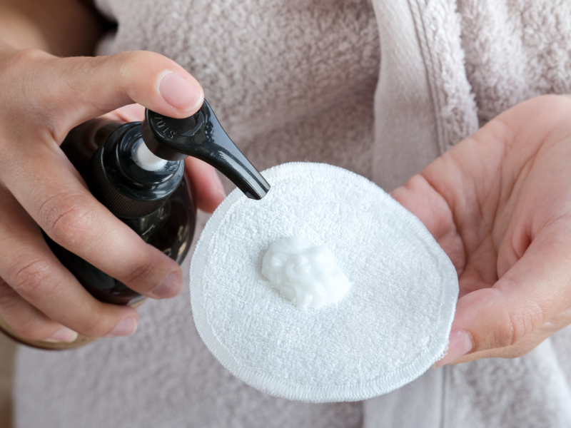 Reiniger auf einem Wattepad.